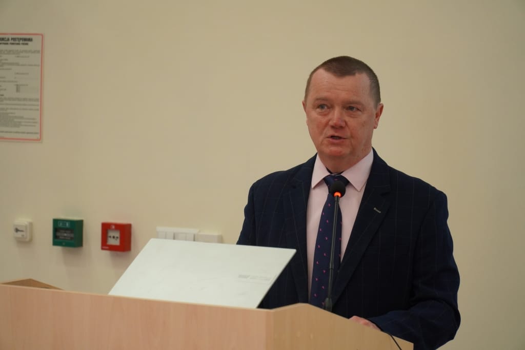 Mężczyzna w garniturze przemawia na IX Konferencji Naukowej