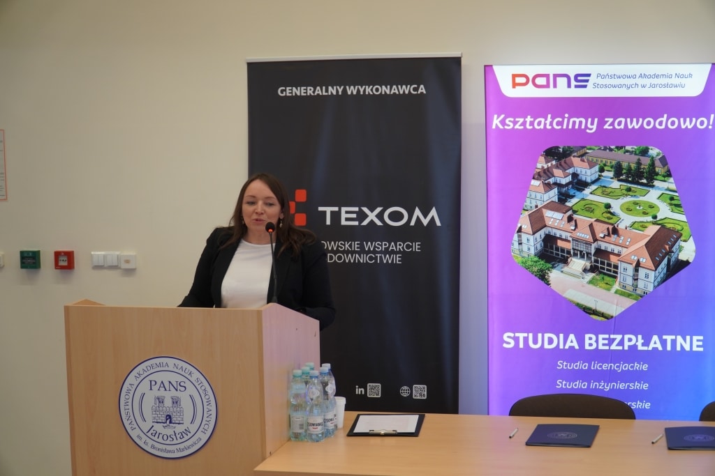Kobieta przemawia na konferencji budowlanej PANS Jarosław