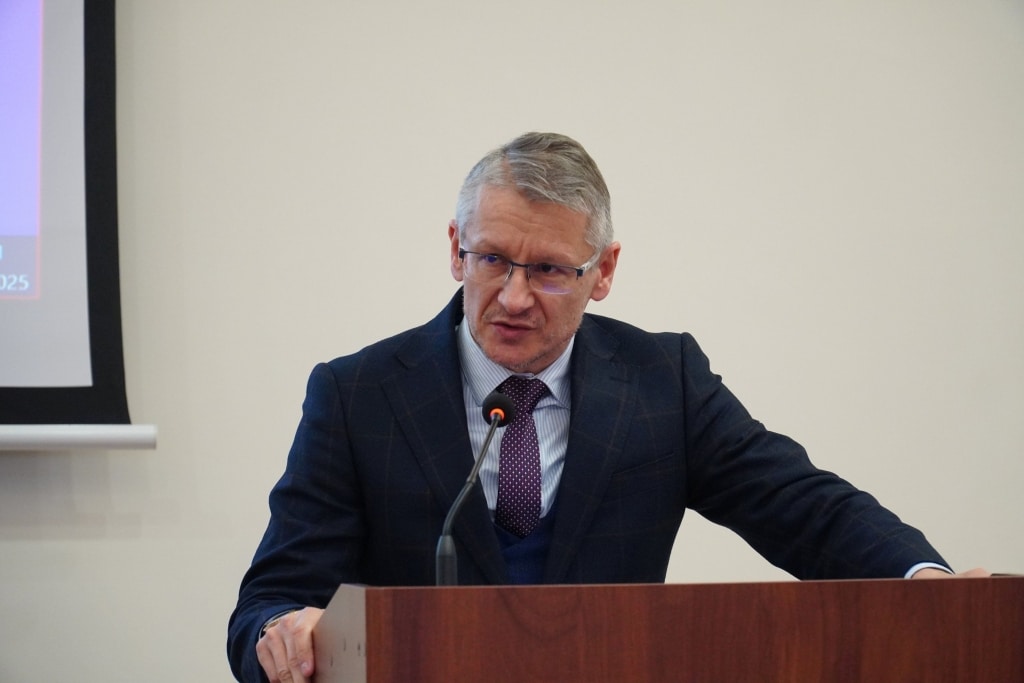 Mężczyzna w garniturze przemawia na konferencji naukowej o bezpieczeństwie informacyjnym.