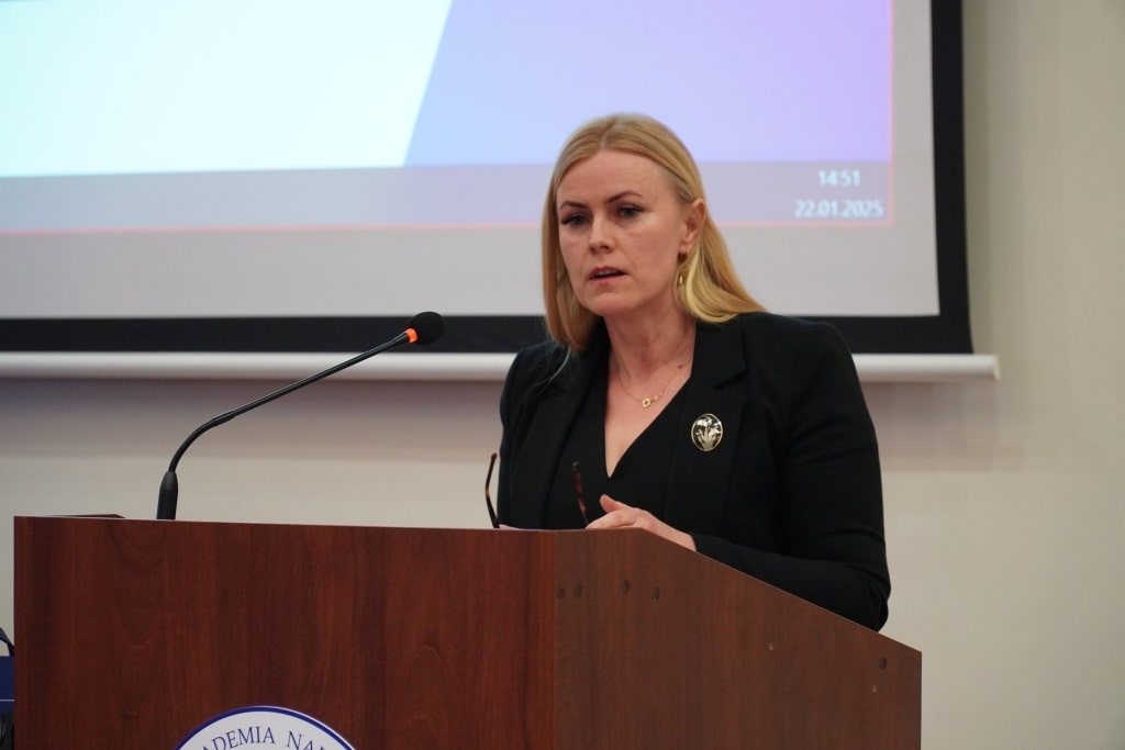 Kobieta przemawia na konferencji naukowej Bezpieczeństwo Informacyjne w Zarządzaniu Kryzysowym.
