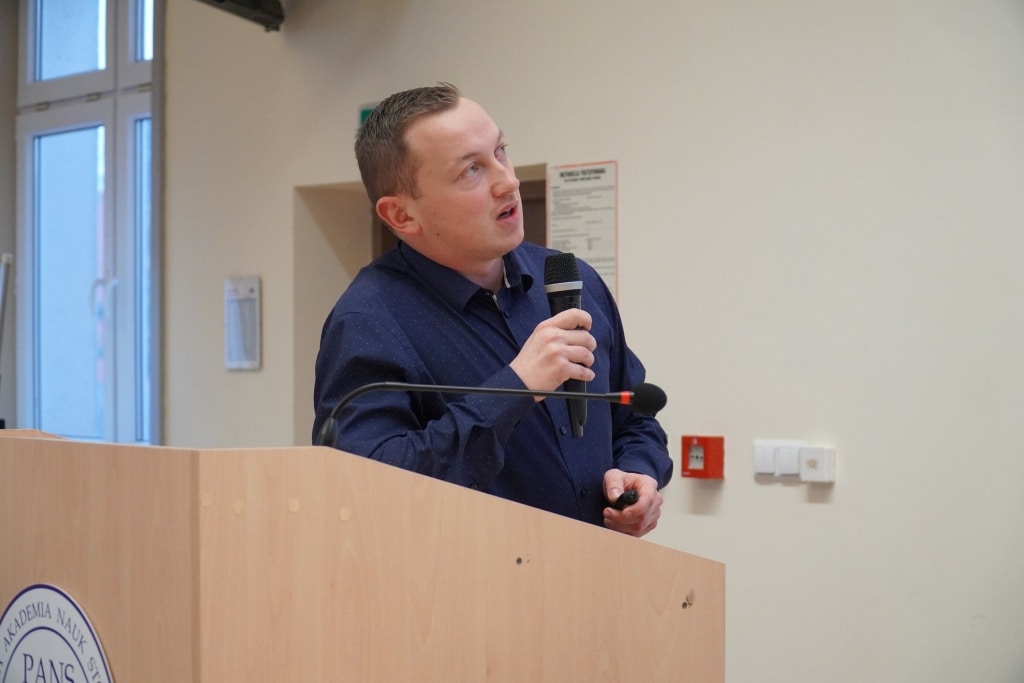 Mężczyzna przemawia na konferencji naukowej Bezpieczeństwo Informacyjne w Zarządzaniu Kryzysowym