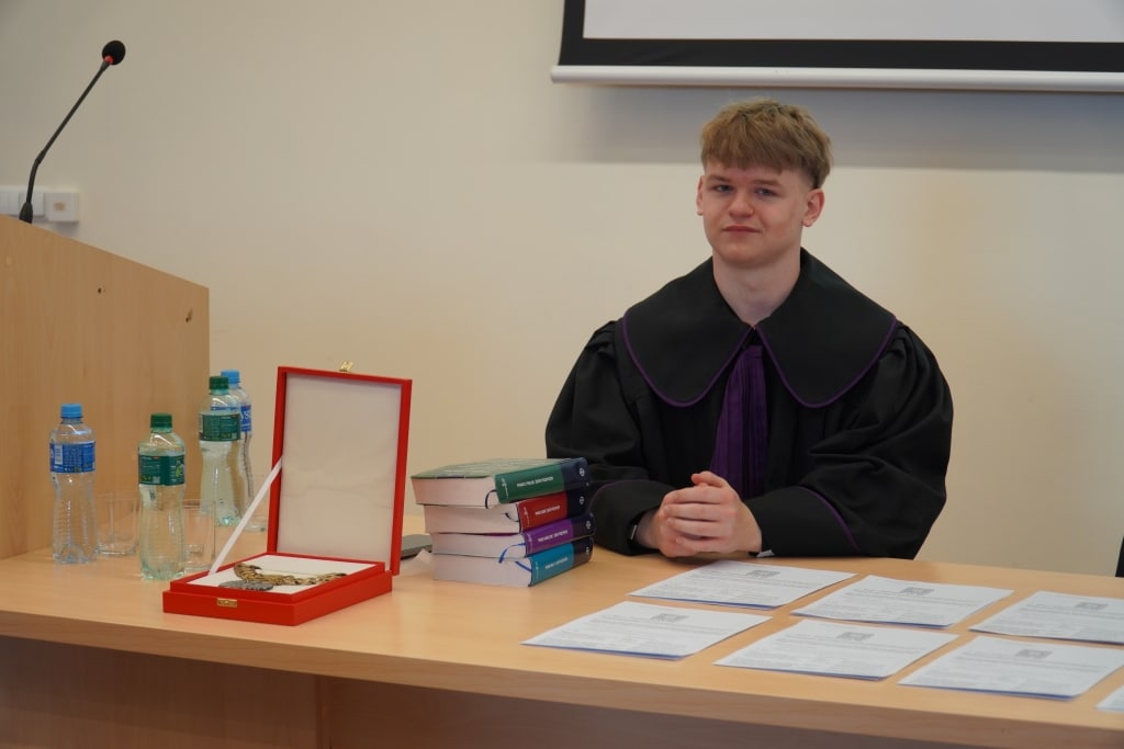 Młody mężczyzna w todze prawniczej podczas symulacji rozprawy sądowej „Meandry prawa”
