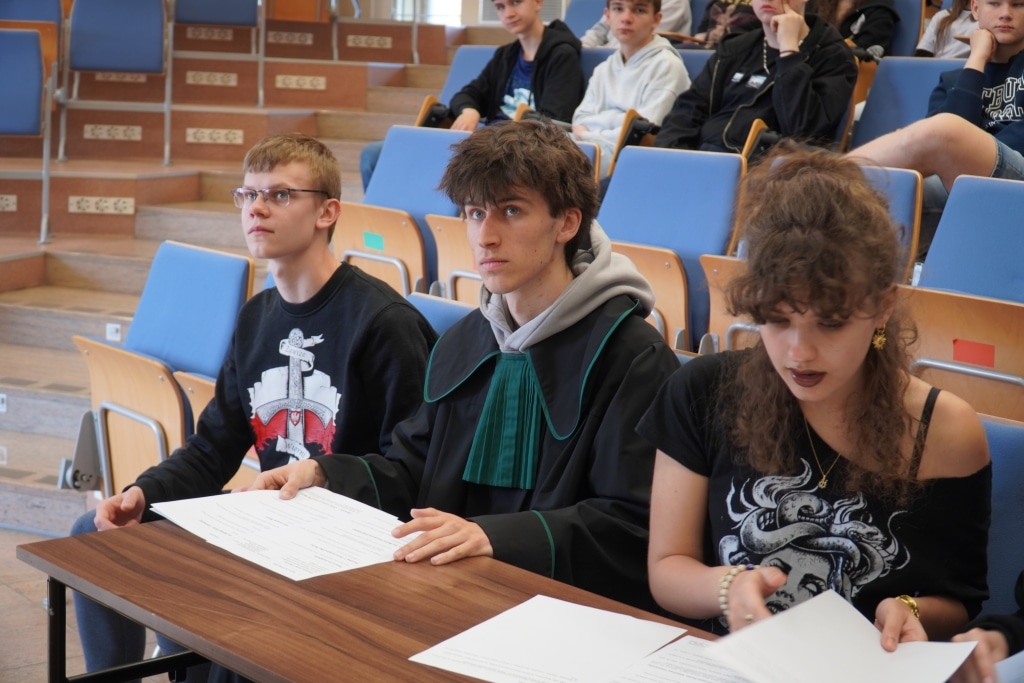Młodzi ludzie w togach prawniczych podczas symulacji rozprawy sądowej „Meandry prawa”