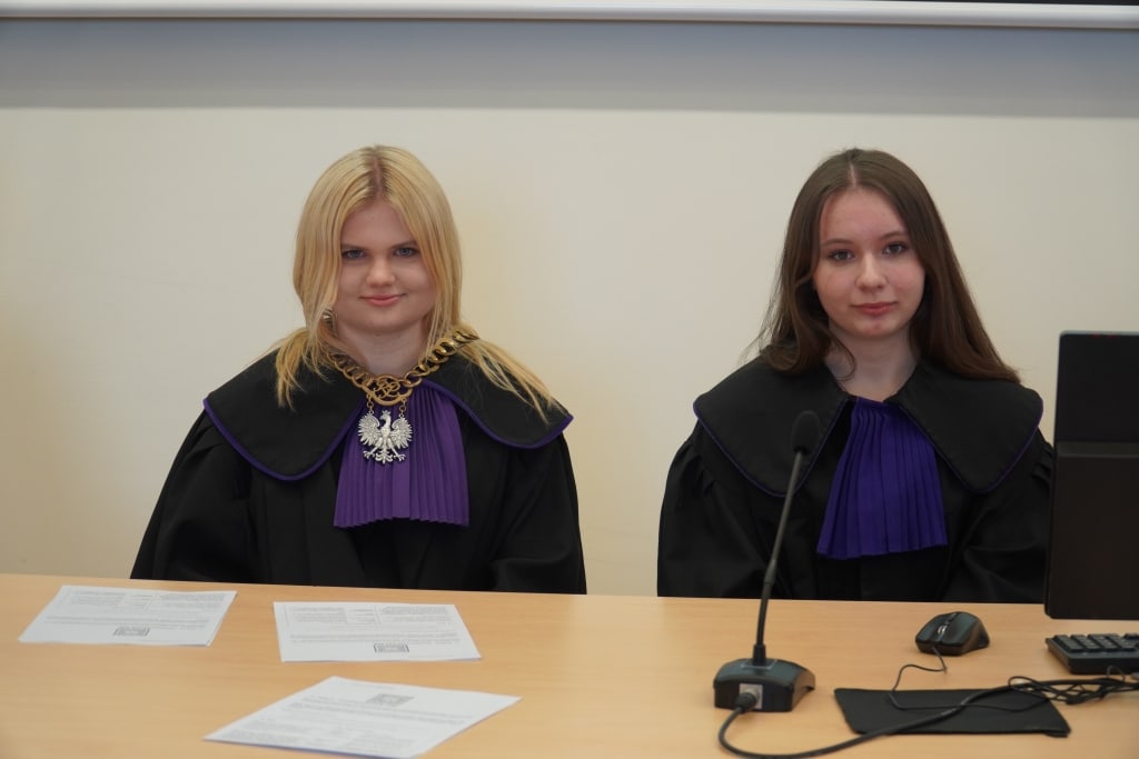 Symulacja rozprawy sądowej: dwie studentki prawa w togach.