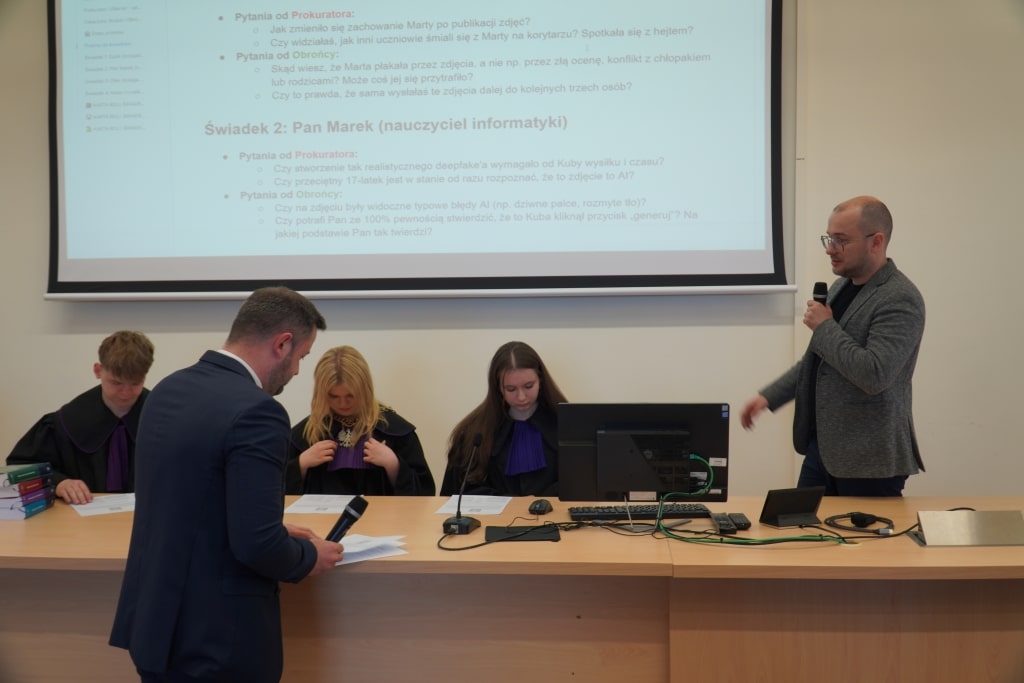 Symulacja rozprawy sądowej: prelegent prowadzi debatę, studenci w togach sądowych.