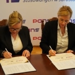 Dwie kobiety podpisują dokumenty z Fundacją LANISTA