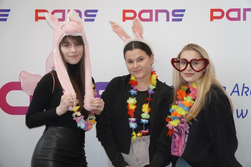Studentki na Dniu Studenta w PANS z kwiatowymi girlandami i akcesoriami.