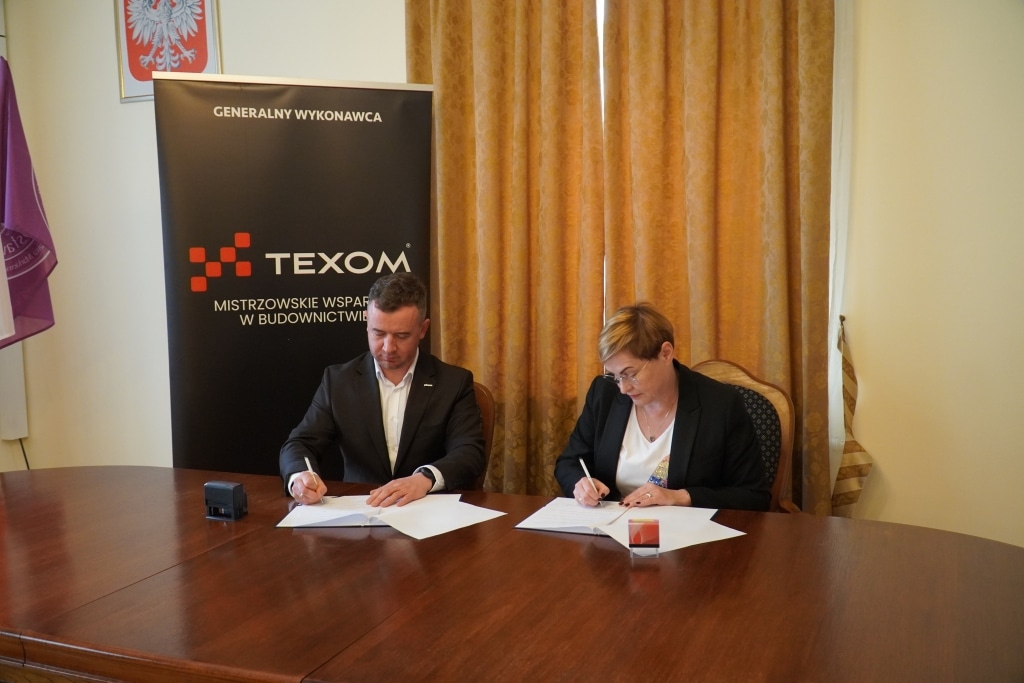 Podpisanie umowy o współpracy z TEXOM: mężczyzna i kobieta podpisują dokumenty
