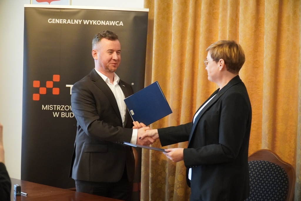 Podpisanie umowy o współpracy z firmą TEXOM: Dyrektor TEXOM i przedstawicielka firmy wymieniają dokumenty