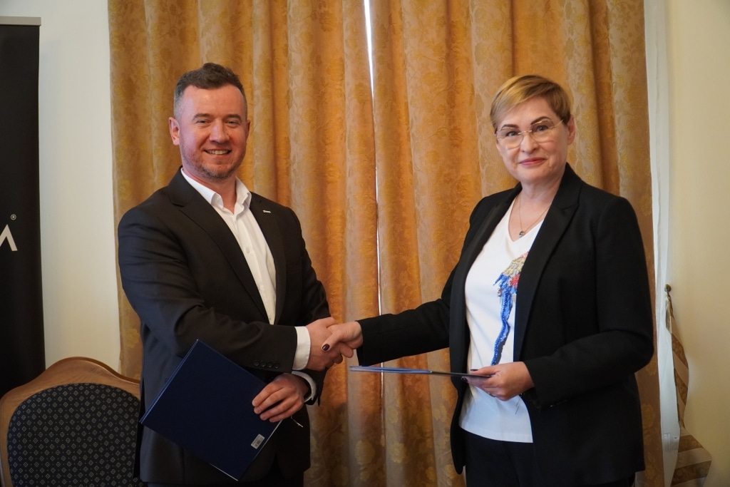 Podpisanie umowy o współpracy z firmą TEXOM: mężczyzna i kobieta podają sobie ręce.