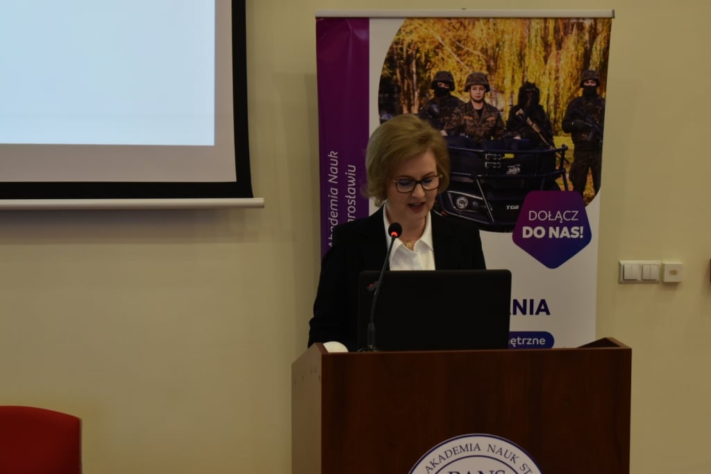 Kobieta przemawia na konferencji naukowej o bezpieczeństwie informacyjnym