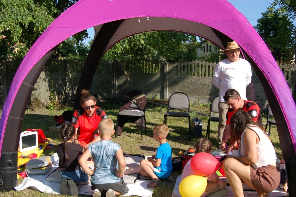 Piknik rodzinny w Łowcach: dzieci i dorośli pod fioletowym namiotem