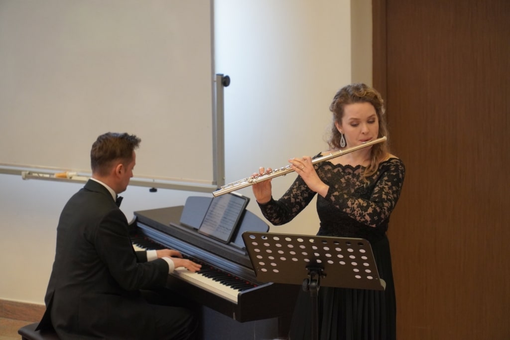 Muzycy grają na pianinie i flecie podczas konferencji naukowej WH