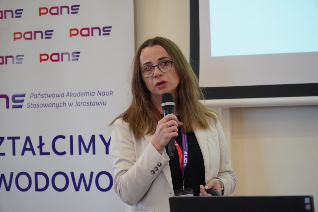 Kobieta z mikrofonem na konferencji naukowej WH w Jarosławiu