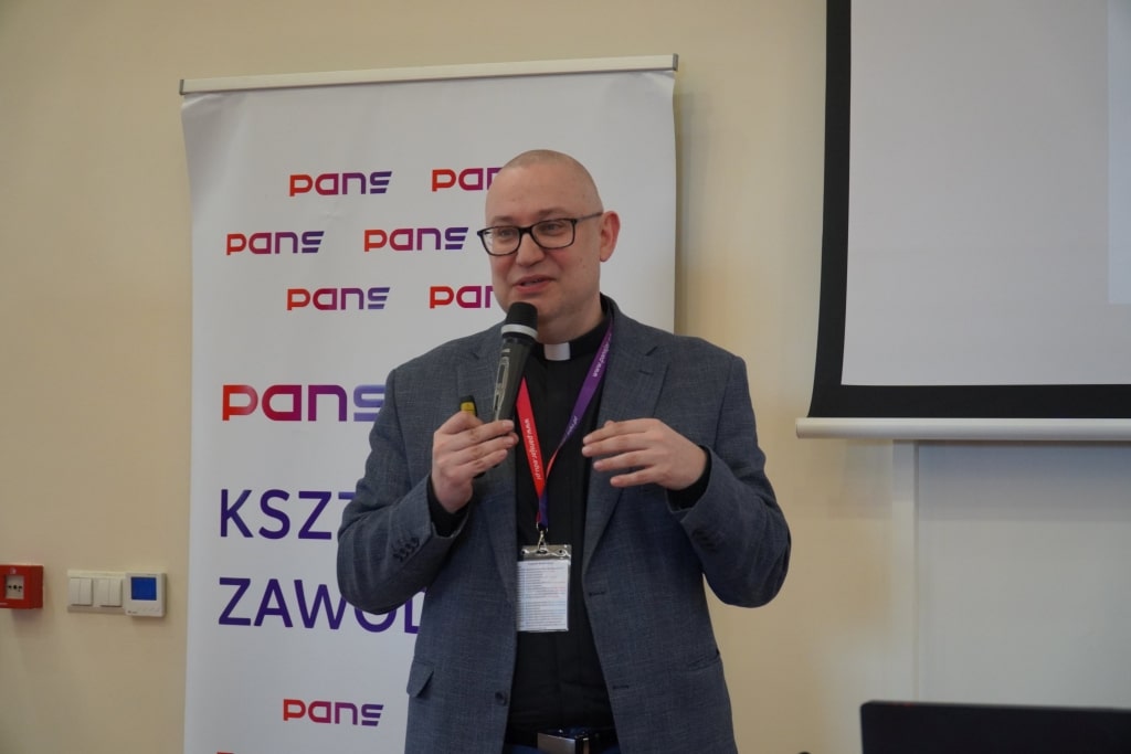 Konferencja naukowa WH: Mówca w garniturze z mikrofonem