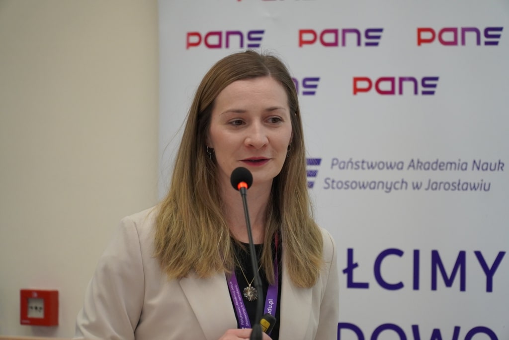 Konferencja naukowa WH: Kobieta przemawia przy mównicy w sali konferencyjnej