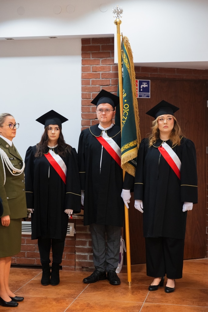 Inauguracja Roku Akademickiego: studenci w togach z flagą