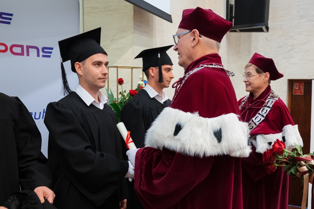 Inauguracja Roku Akademickiego: student odbiera dyplom od rektora