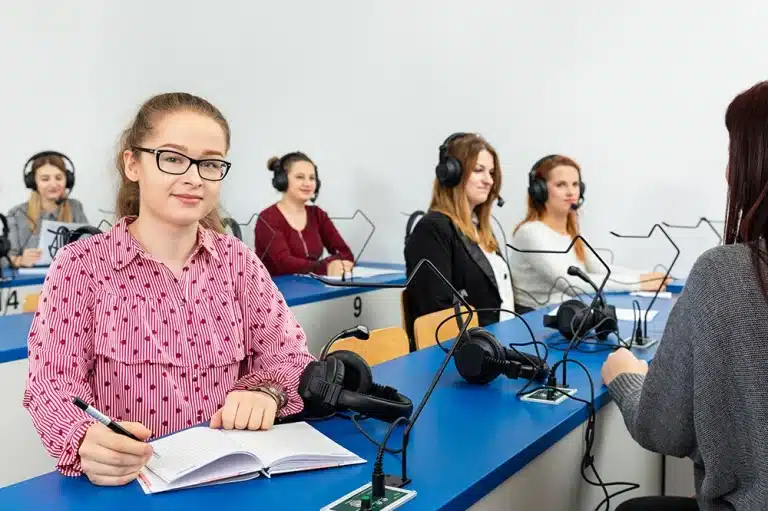 Uczennica w okularach i słuchawkach w sali do nauki języków obcych
