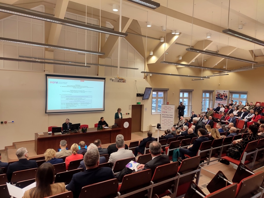 Konferencja Bezpieczeństwo Informacyjne w Zarządzaniu Kryzysowym: sala z prelegentami i uczestnikami.