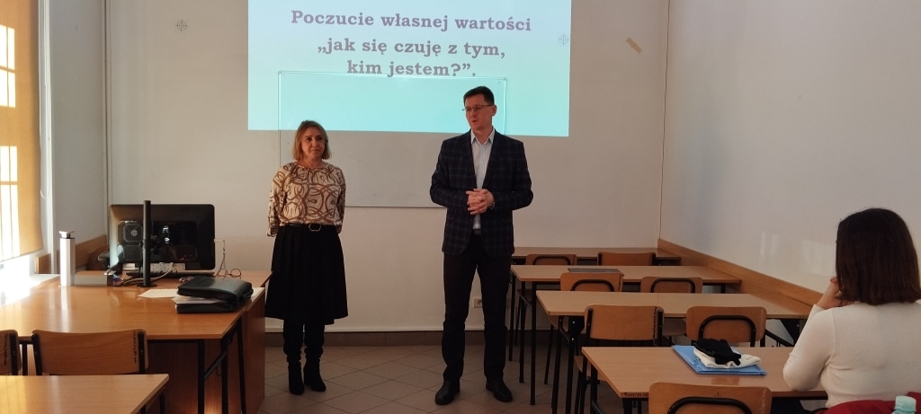 Warsztaty z poczucia własnej wartości: prelegenci przed ekranem z napisem "Jak się czuję z tym, kim jestem?