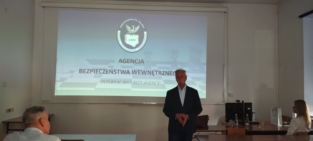 Spotkanie z delegaturą ABW: prelegent przed ekranem z logo Agencji Bezpieczeństwa Wewnętrznego.