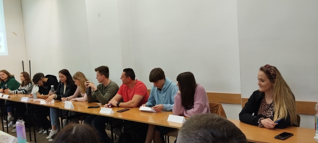 Uczestnicy warsztatów z kreatywności i negocjacji siedzą przy stole.