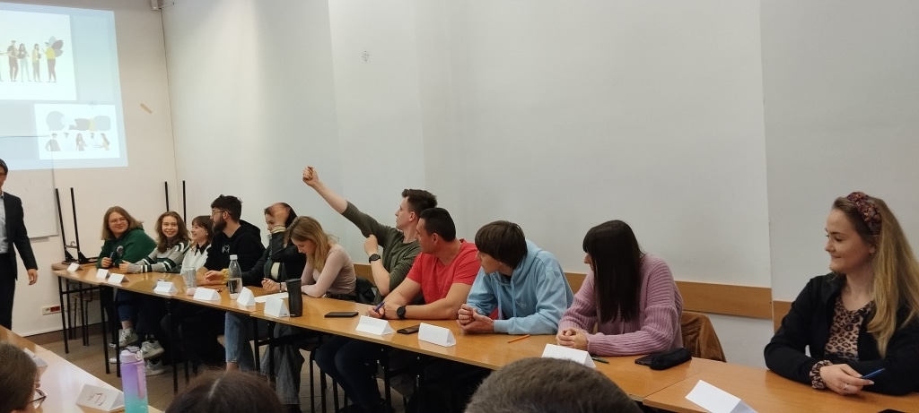 Uczestnicy warsztatów z kreatywności i negocjacji siedzą przy stole.