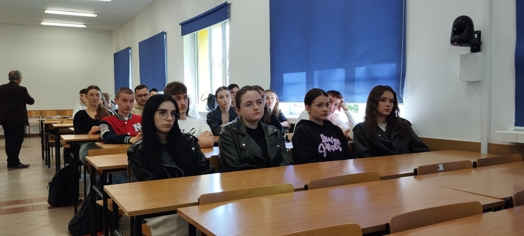 Grupa studentów na spotkaniu z firmą budowlaną BESTA w sali wykładowej.