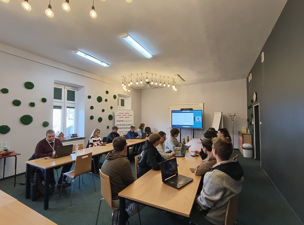 Uczestnicy konferencji RIPE w Jarosławiu przy stołach z laptopami.