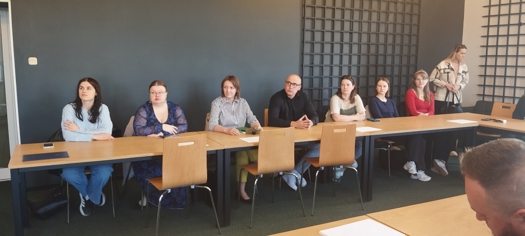 Uczestnicy warsztatów szkoleniowych „Zarządzanie konfliktem i przywództwo sytuacyjne” siedzą przy stole.