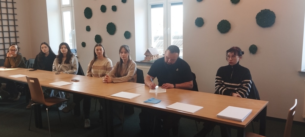 Uczestnicy warsztatów szkoleniowych „Zarządzanie konfliktem i przywództwo sytuacyjne” przy stole.