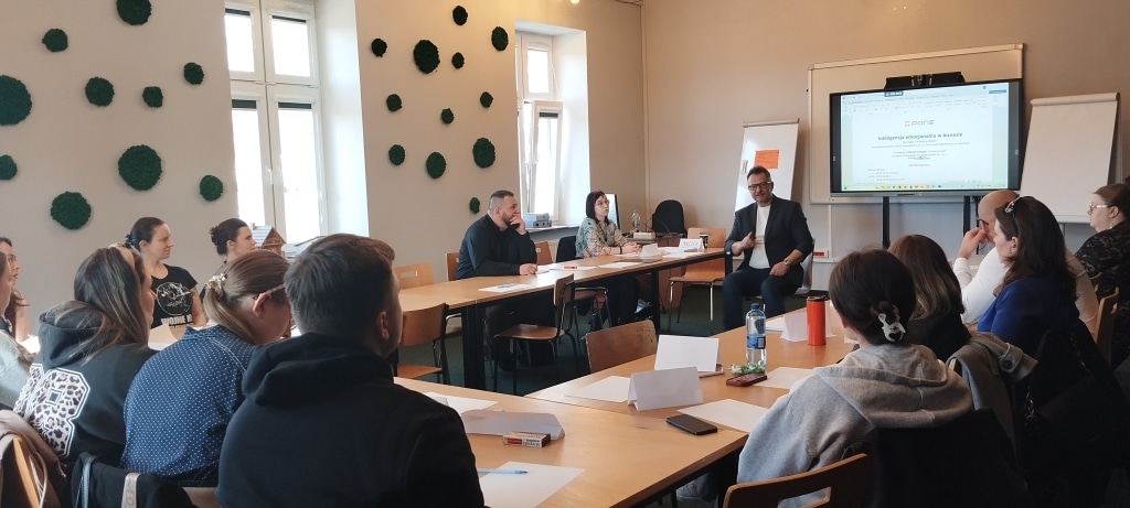 Uczestnicy warsztatów „Inteligencja emocjonalna w biznesie” słuchają trenera.