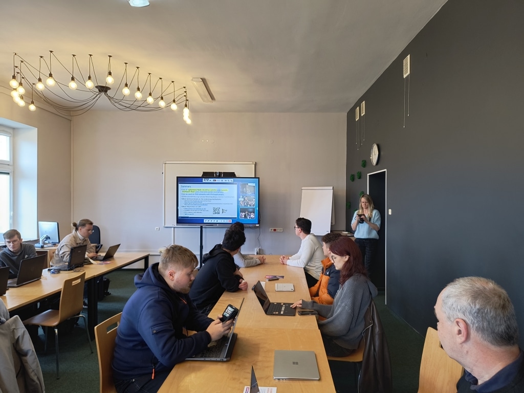 Spotkanie środowiska ISP i ICT podczas RIPE 92 w Jarosławiu: uczestnicy dyskutują przy stole.