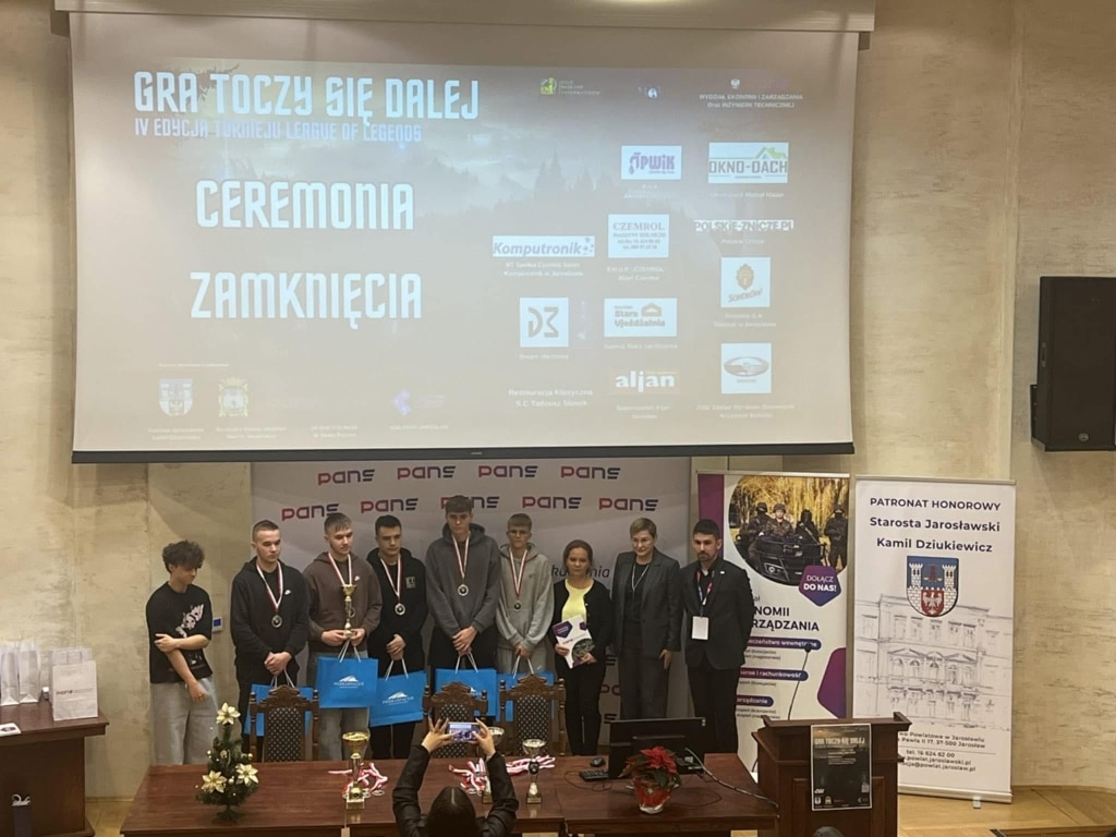 Uczestnicy i organizatorzy IV Edycji Turnieju „League of Legends 2025 – GRA TOCZY SIĘ DALEJ” na scenie.
