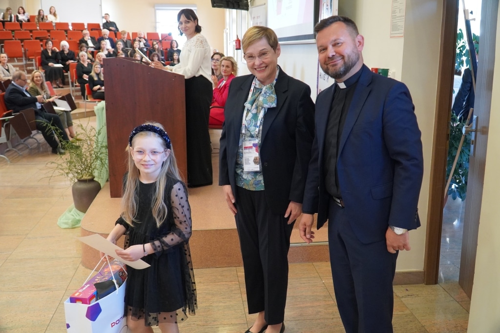 Dziecko z nagrodami na konferencji "Od szkoły tradycyjnej do szkoły innowacyjnej