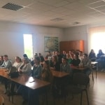 Uczestnicy Dnia Jakości Kształcenia siedzą w sali wykładowej.