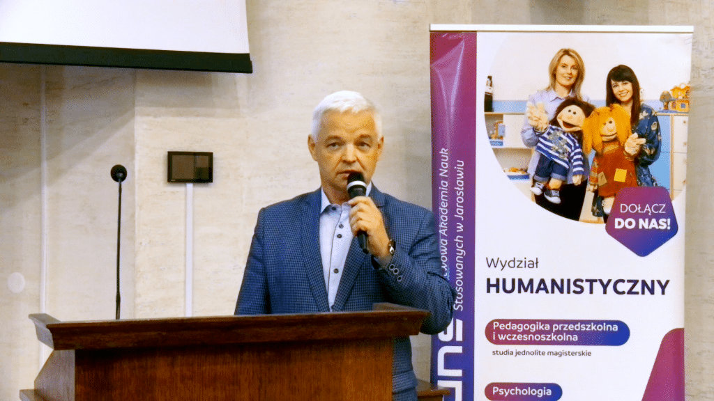 Mężczyzna przemawia na konferencji dla dyrektorów szkół i przedszkoli.