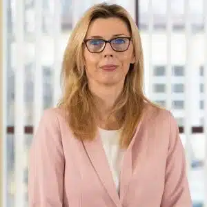 Joanna Dworakowska w różowej marynarce i okularach