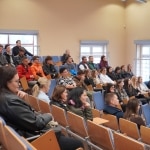 Uczestnicy spotkania organizacyjnego siedzą na widowni w sali wykładowej.