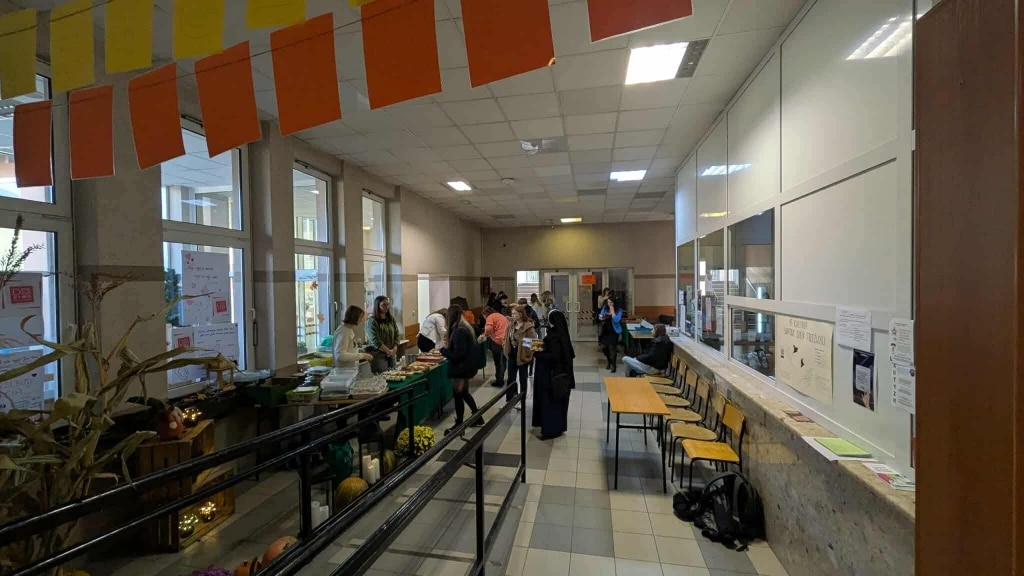 Kiermasz ciast na Wydziale Humanistycznym PANS w Jarosławiu: stoiska z wypiekami i ludzie