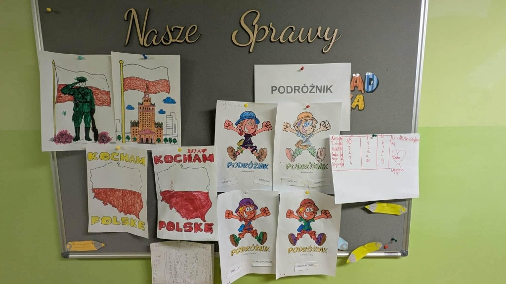 Plakat z polskimi symbolami narodowymi i rysunkami dzieci w szkole.