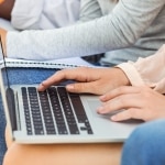 Uczestnicy warsztatu motywacji pracujący na laptopach i notujący.