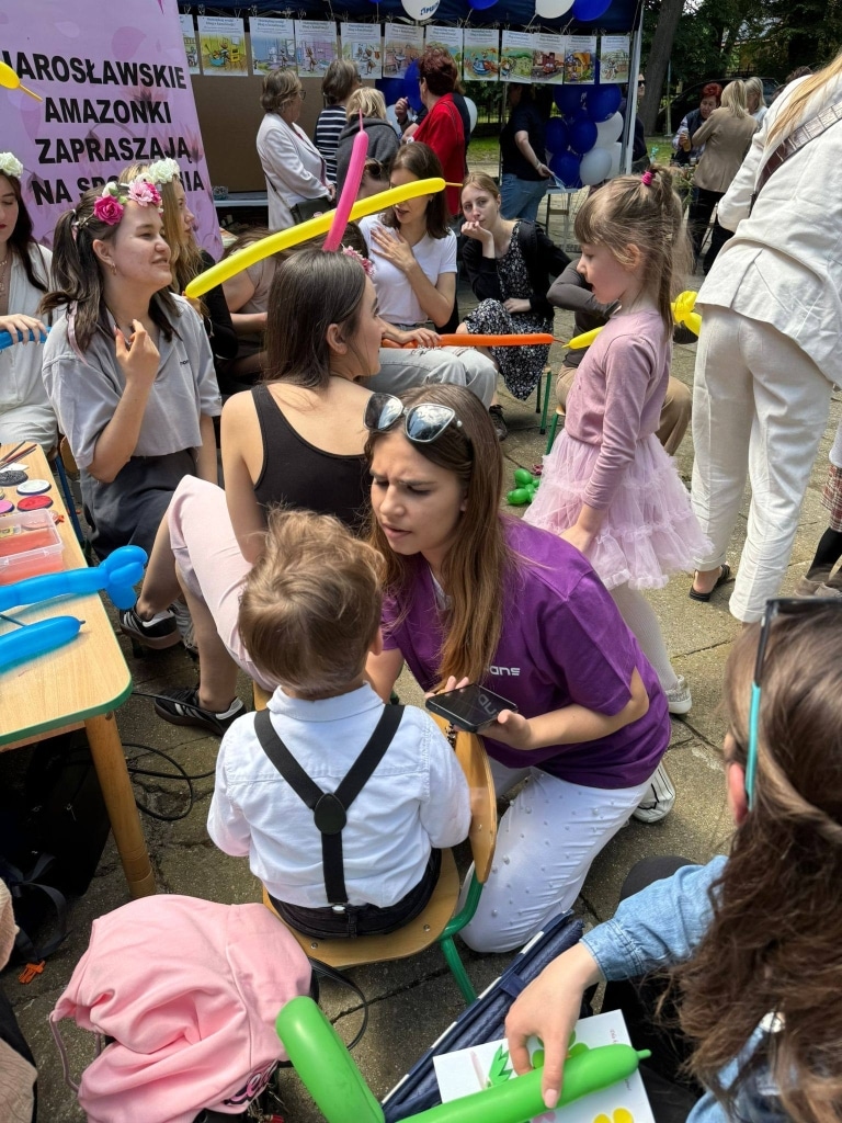 Piknik rodzinny: dzieci i rodzice cieszący się balonami i grami na świeżym powietrzu.