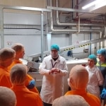 Wizyta studyjna w fabryce ciastek Mondelez: przewodnik opowiada grupie o procesie produkcji.