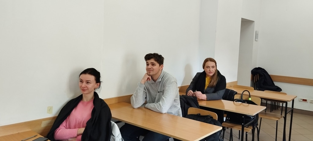 Uczestnicy warsztatów o dokumentach aplikacyjnych siedzą przy ławkach w sali.