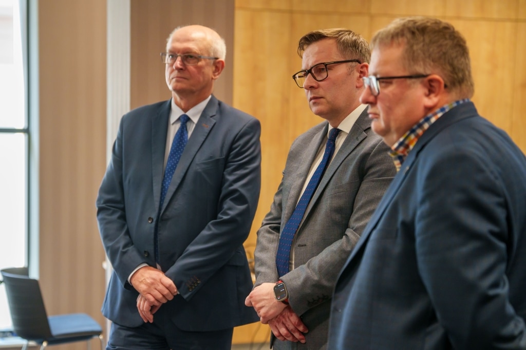 Trzech mężczyzn w garniturach podczas spotkania Klastra 8Foundry-Alliance w Jarosławiu.