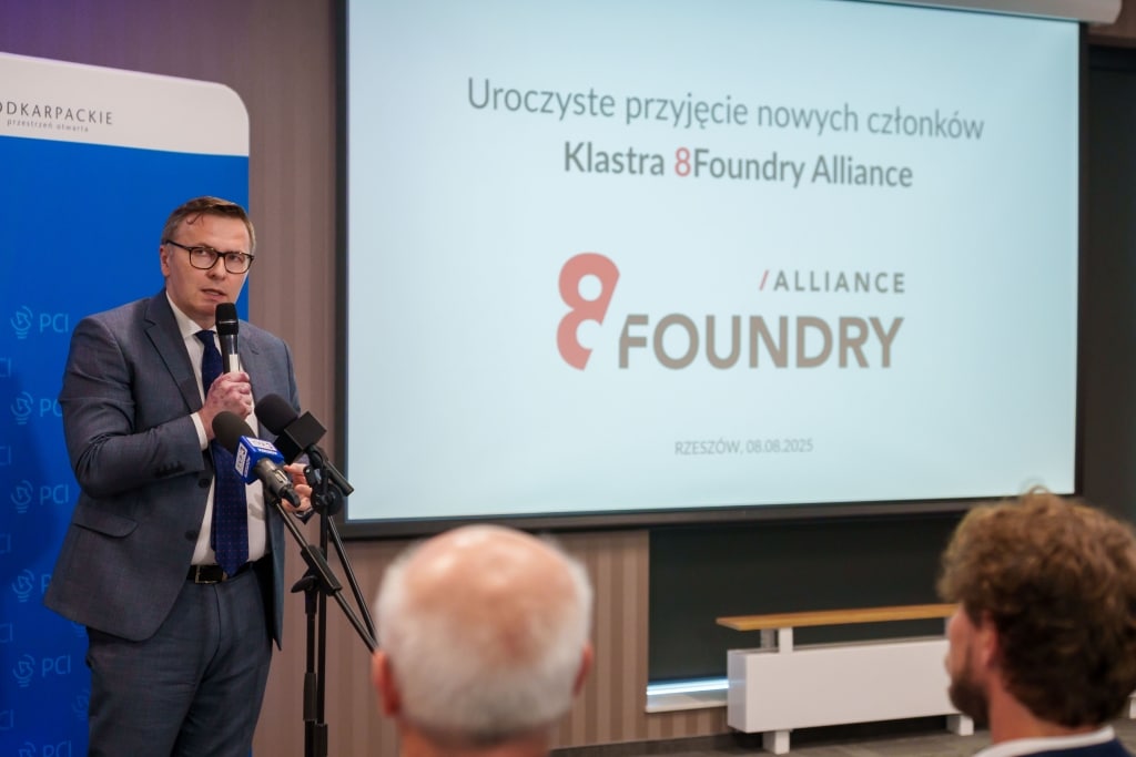Mężczyzna przemawia na tle logo Klastra 8Foundry-Alliance w Rzeszowie.