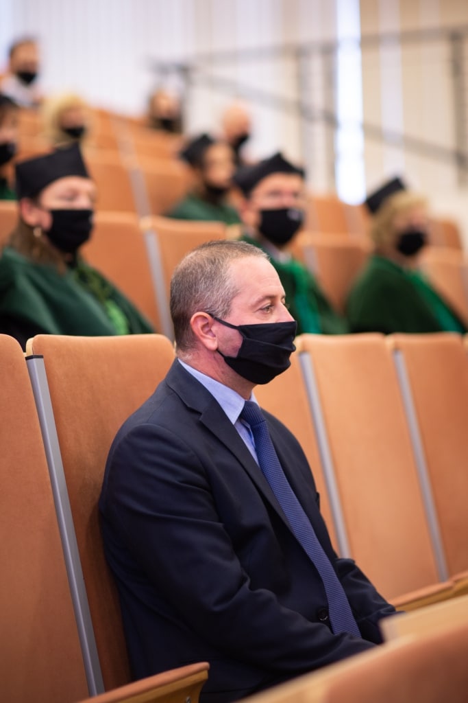 Inauguracja 2021/2022: Mężczyzna w garniturze i maseczce siedzi na widowni.