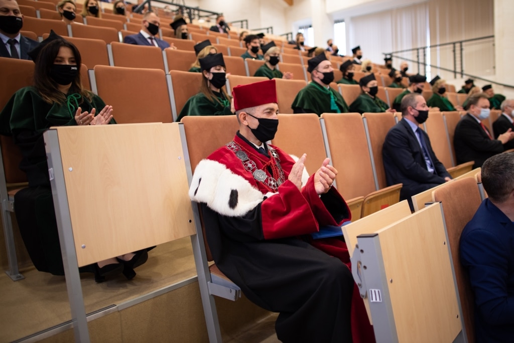Inauguracja 2021/2022: Uczestnicy w togach i biretach siedzą na widowni